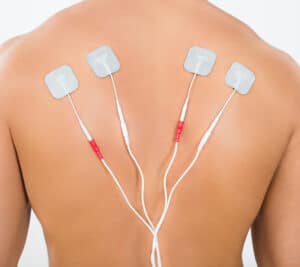 Aufgeklebte Pads im Schulterbereich zur Elektrotherapie