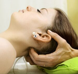 Osteopathie Nahaufnahme, Hände halten Kopf einer Patientin