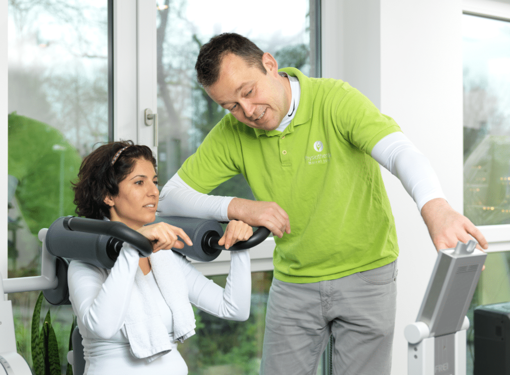 Marcel Jonas mit einer Patientin bei der Krankengymnastik am Gerät