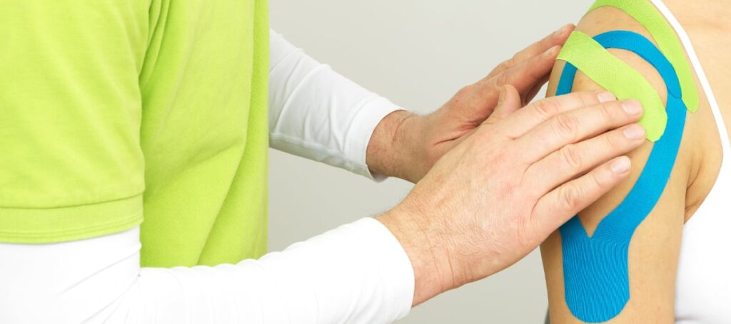 Chiro Taping Therapie mit mehreren farbigen Tapes zur Entlastung der Schulter